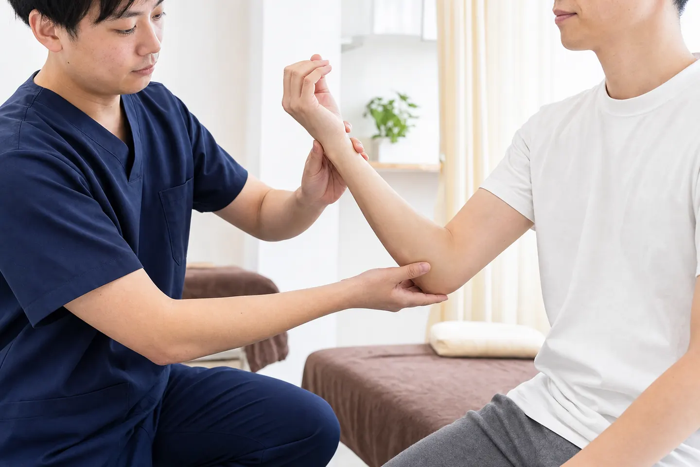 医療機関受診後に手首と肘の動きを整骨院で確認する様子