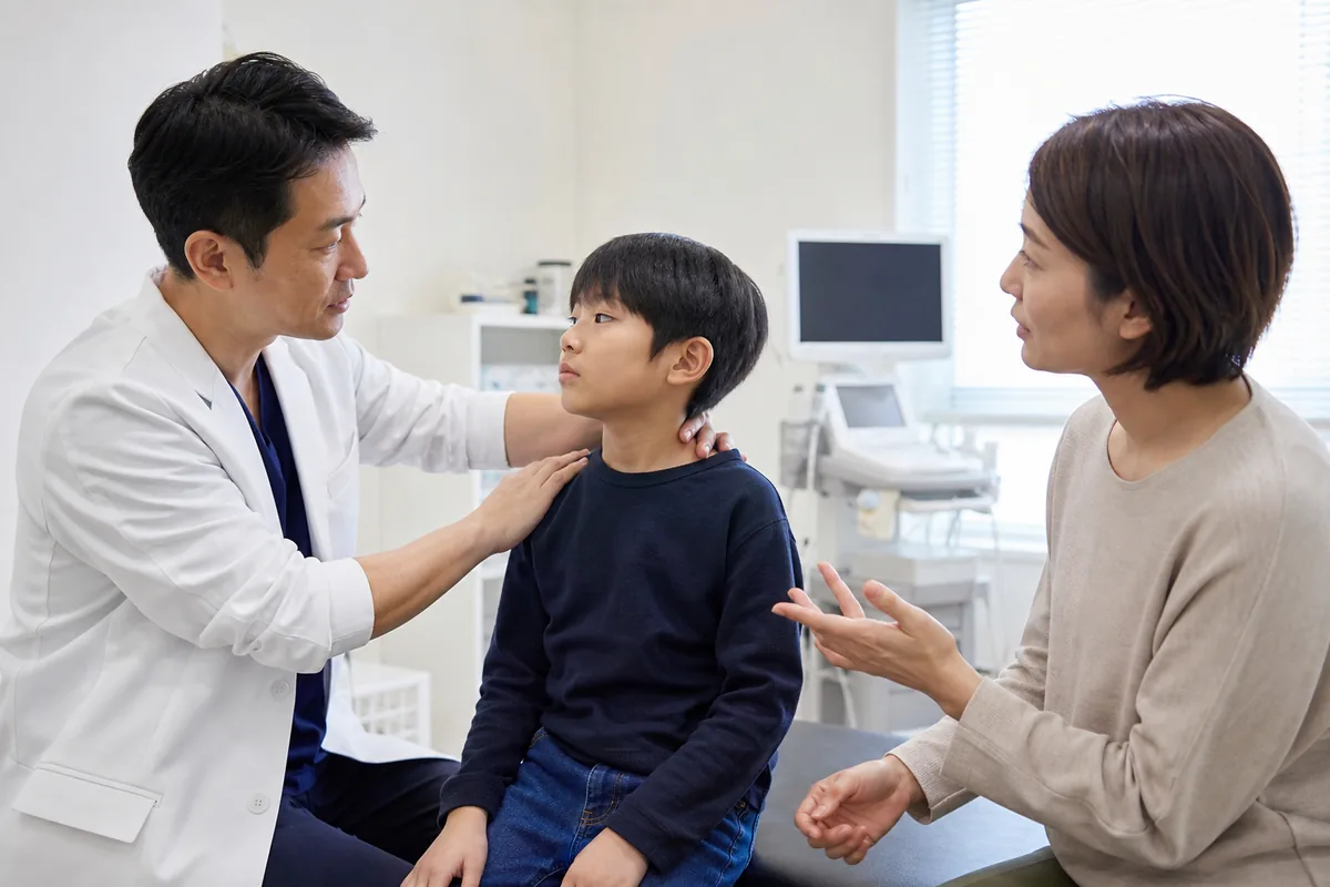 交通事故後の子どもの首と肩を病院で診察する医師と保護者